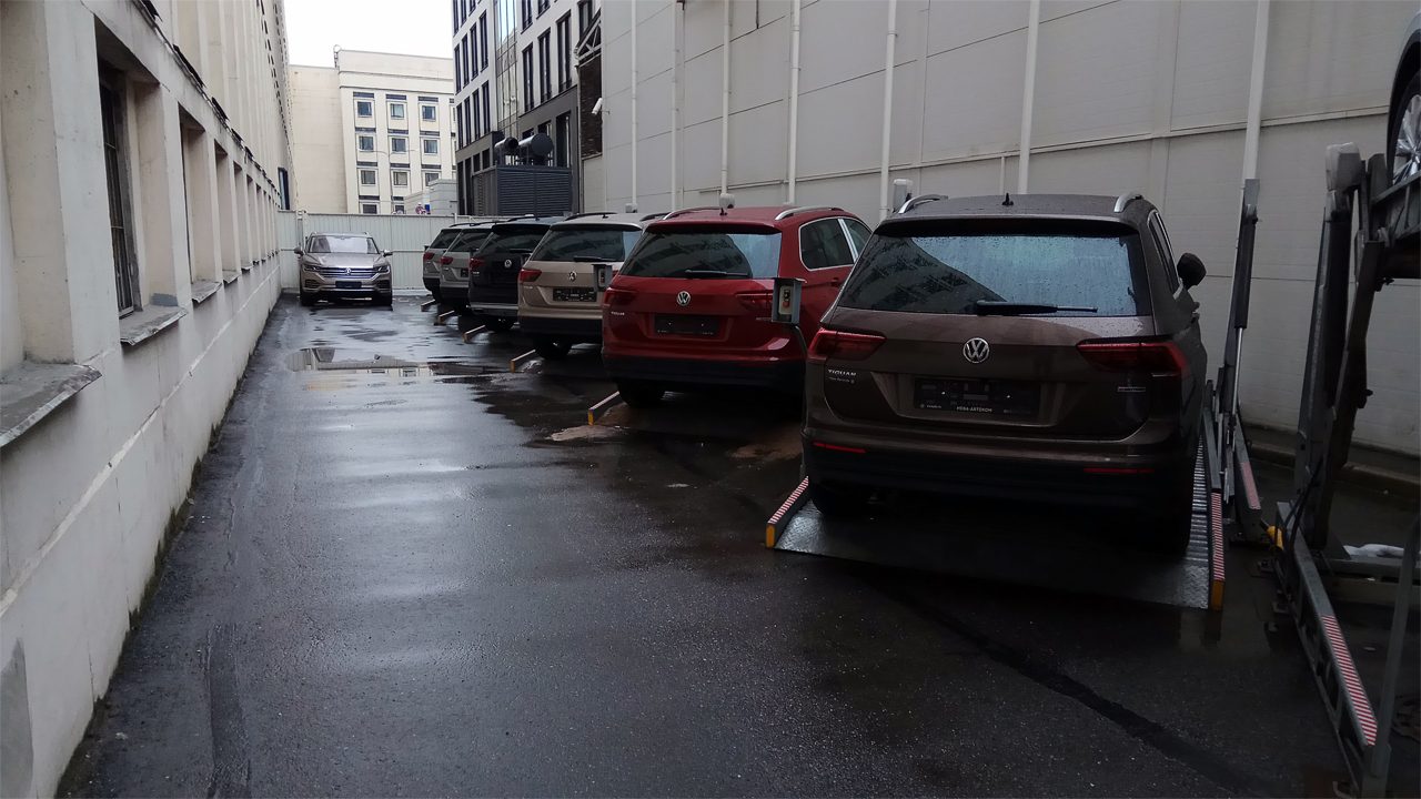 Подъёмники с автомобилями на парковке