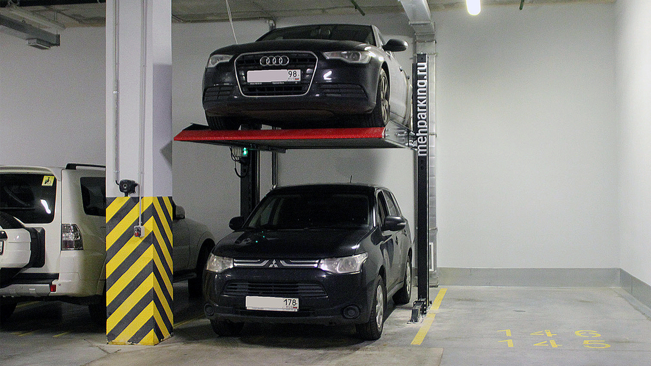 Частные автомобили на парковочном подъёмнике в паркинге